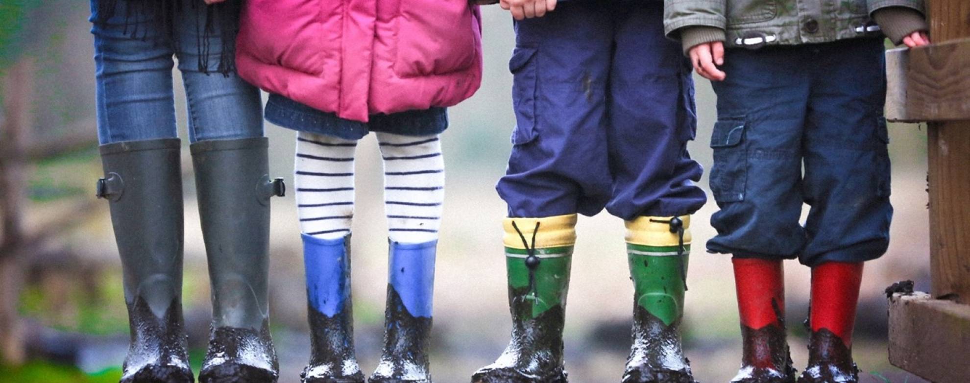 Picture of children wearing muddied rainboots 
